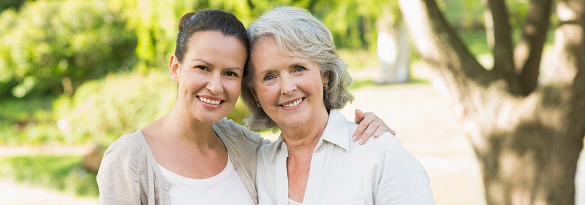 Portrait of a smiling mature woman with adult daughter at the park